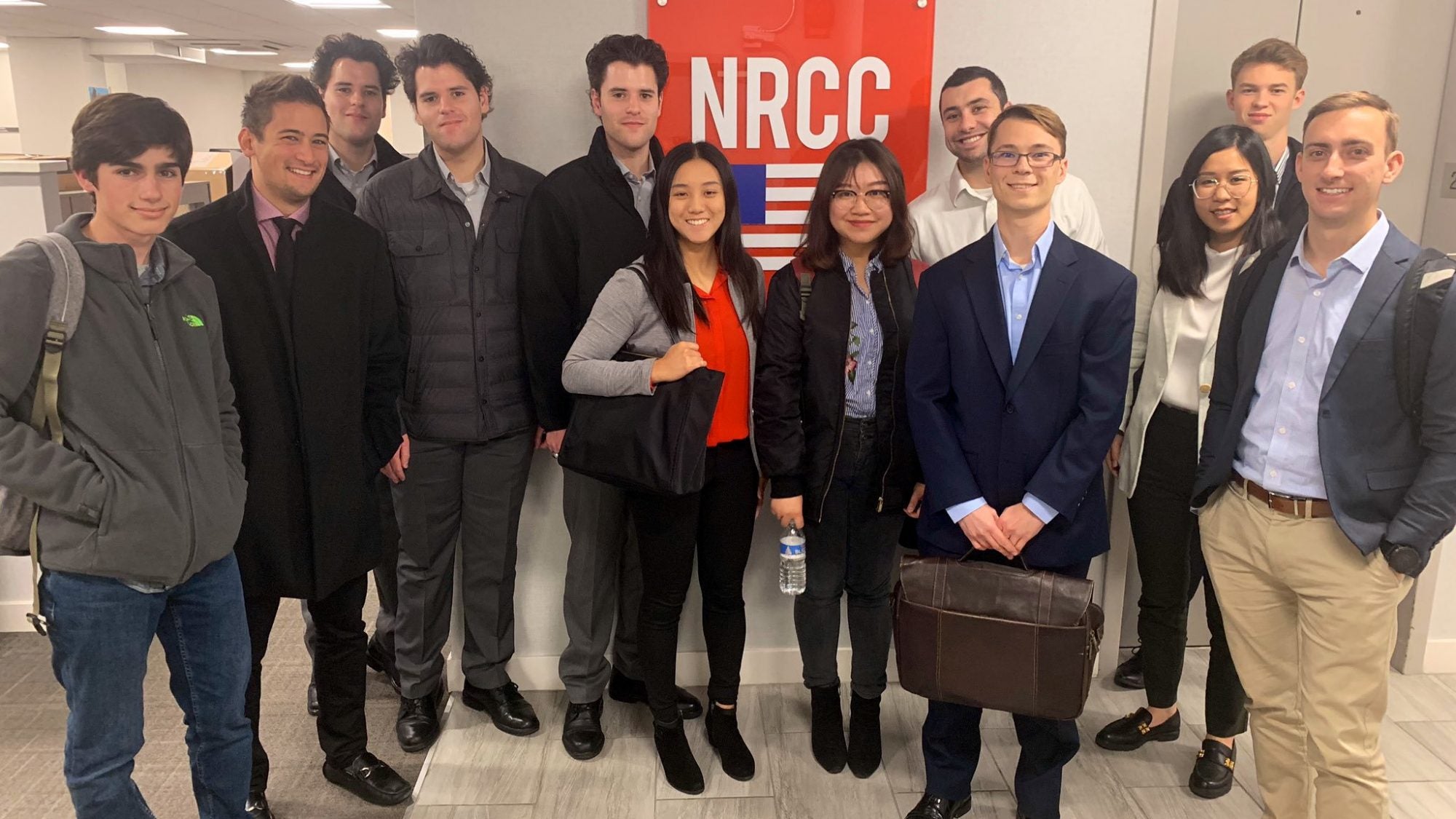 Students at the NRCC office in front of logo.