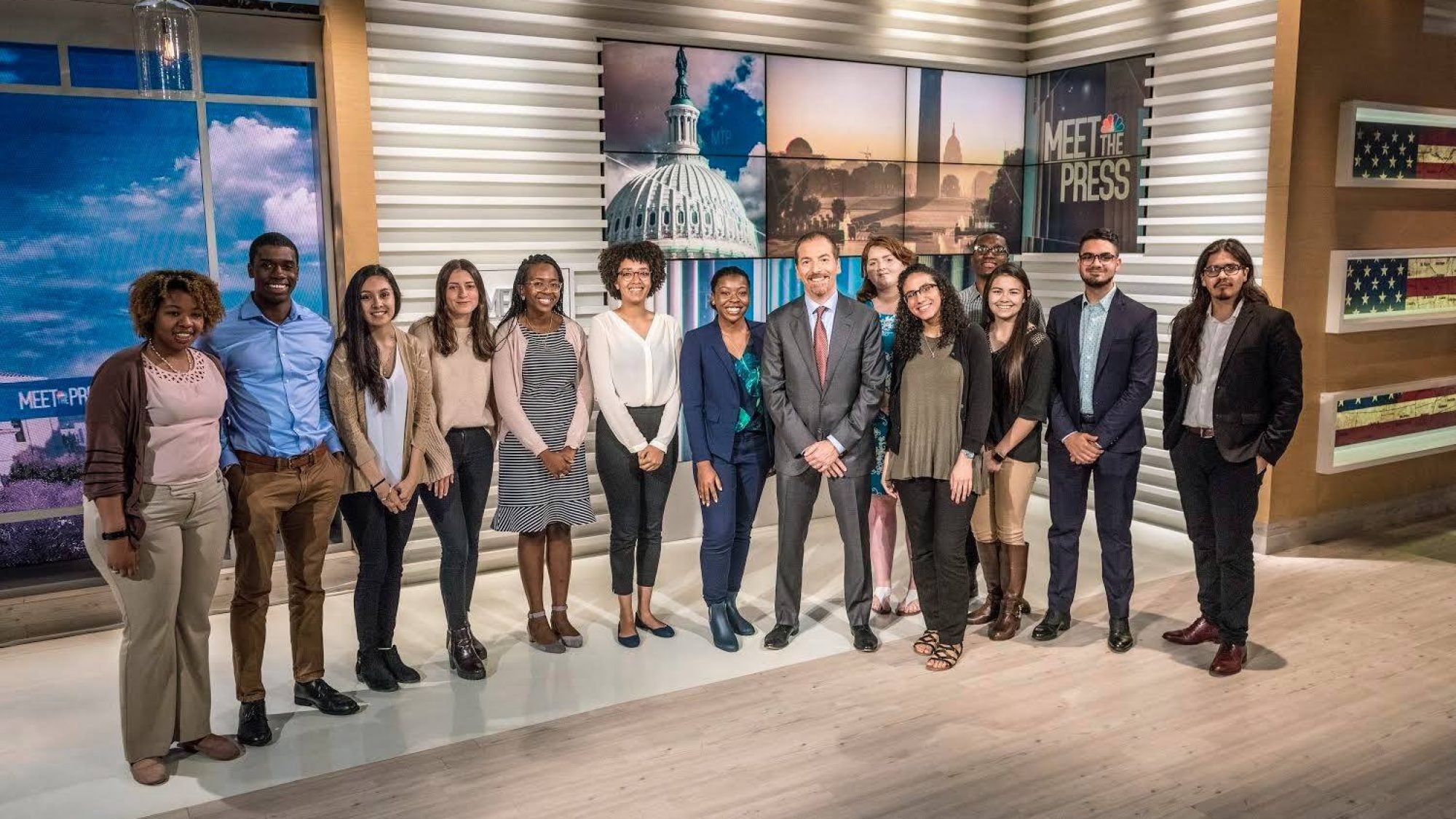 Students stand in news room with Chuck Todd.