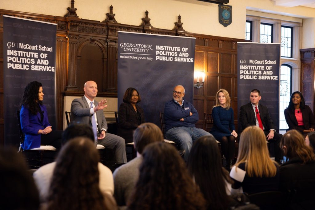 Spring 2024 Fellows and Mo Elleithee sit onstage in Copley Hall.