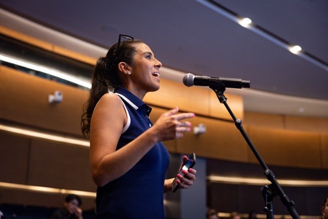 A student asks a question from the audience. 
