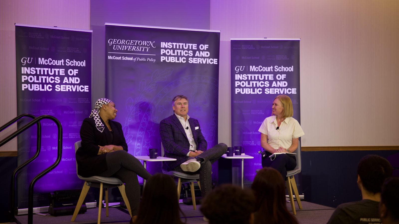 Photo of Symone Sanders Townsend, Mike Dubke and Jackie Kucinich speaking from stage.