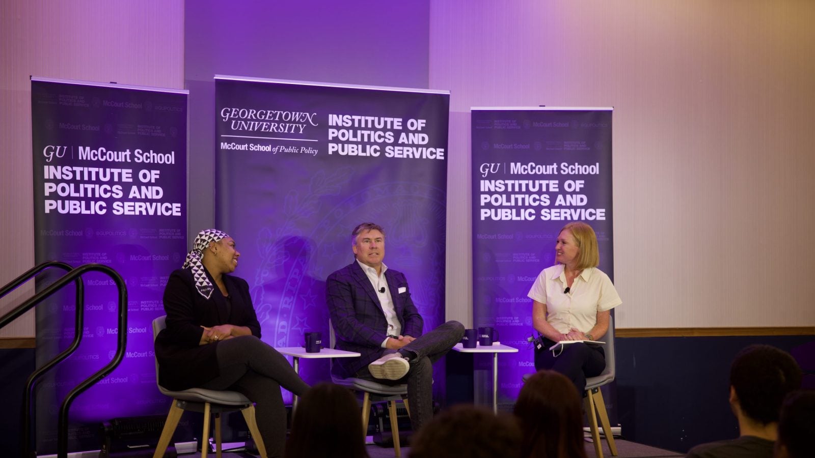 Photo of Symone Sanders Townsend, Mike Dubke and Jackie Kucinich speaking from stage.