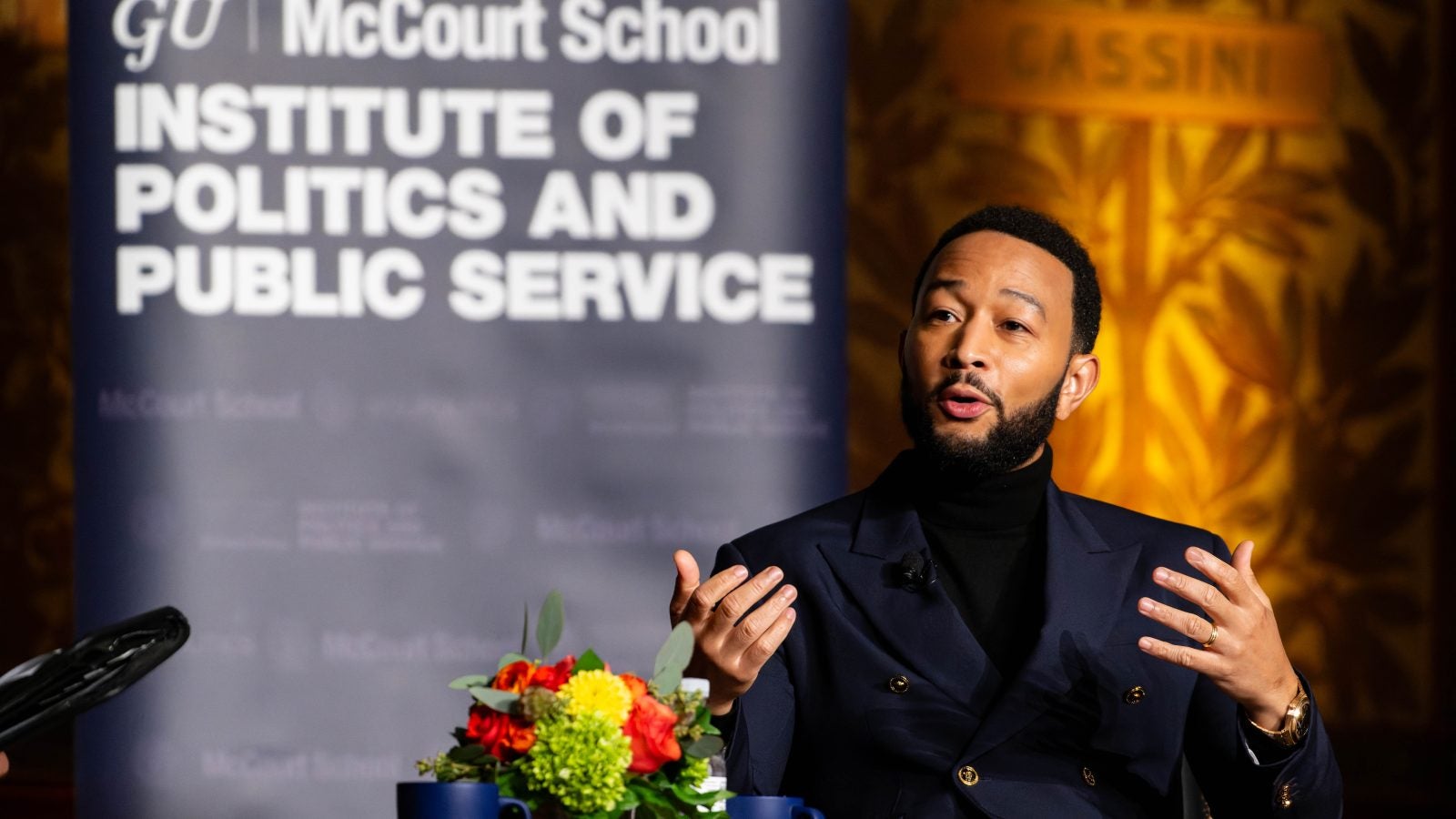 Photo of John Legend speaking while seated