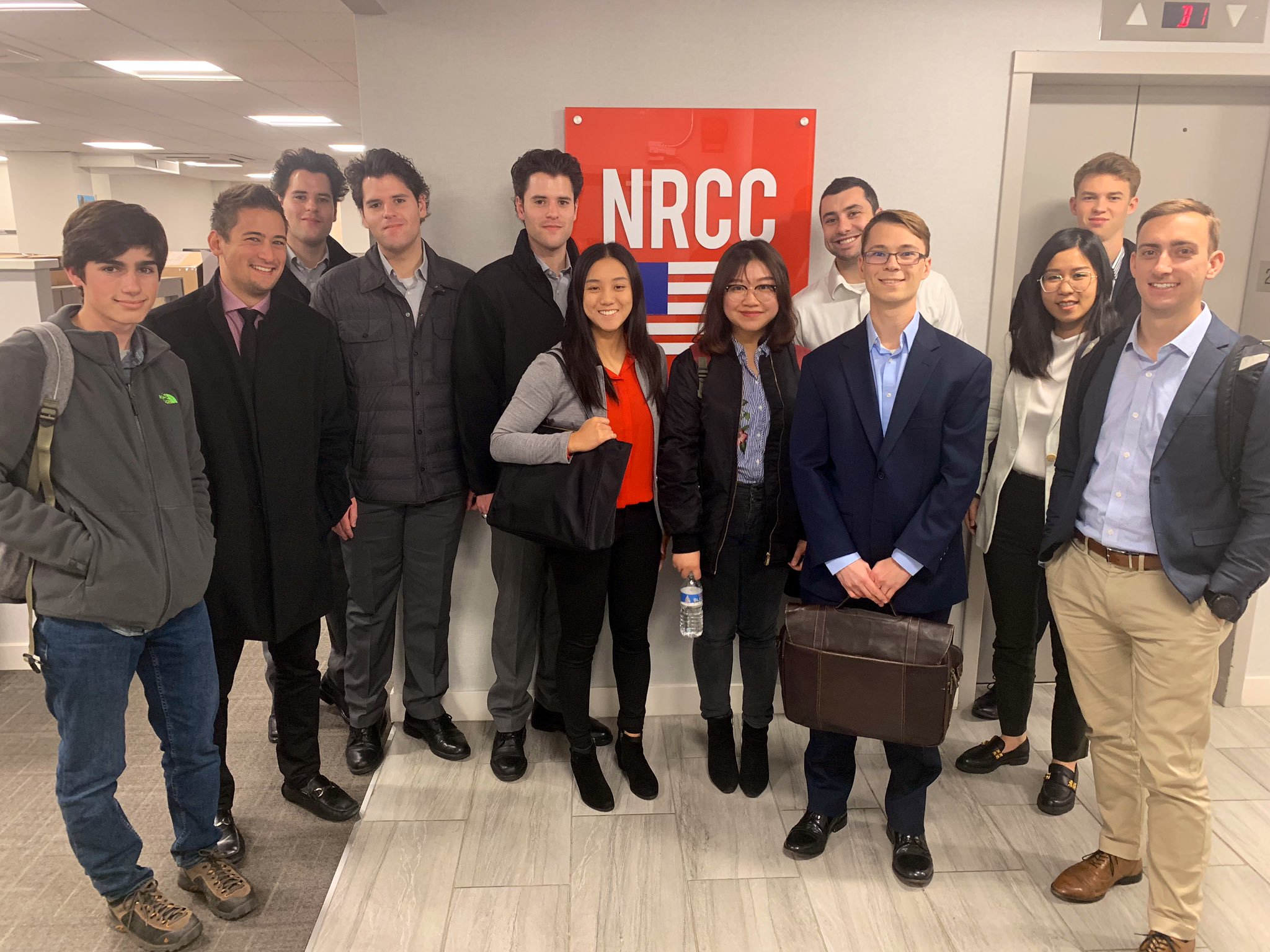 Students at the NRCC office in front of logo.