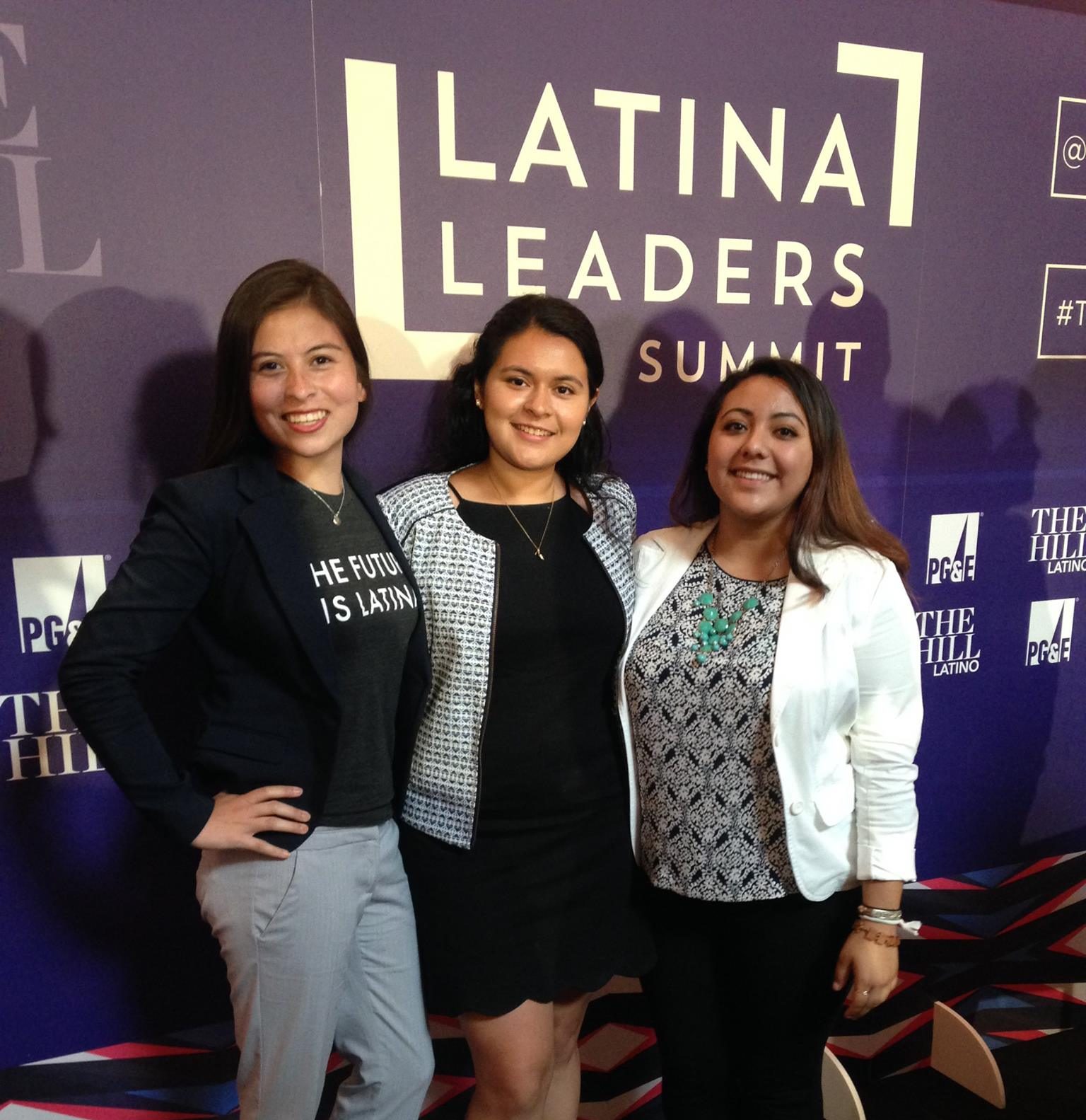 Students stand in front of sign that reads 