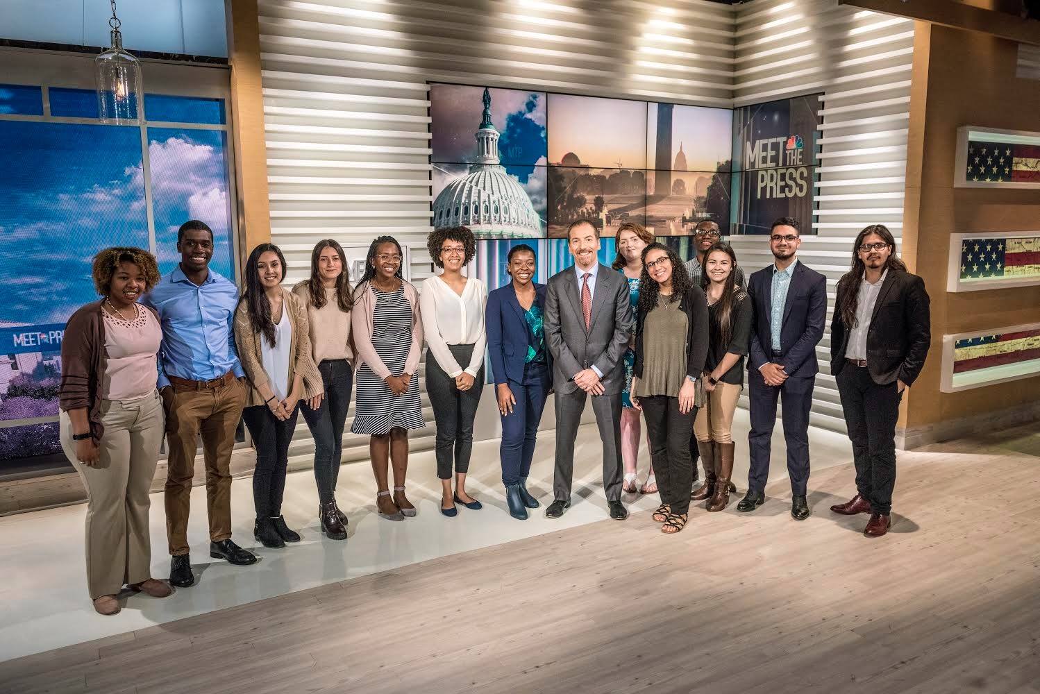Students stand in news room with Chuck Todd.