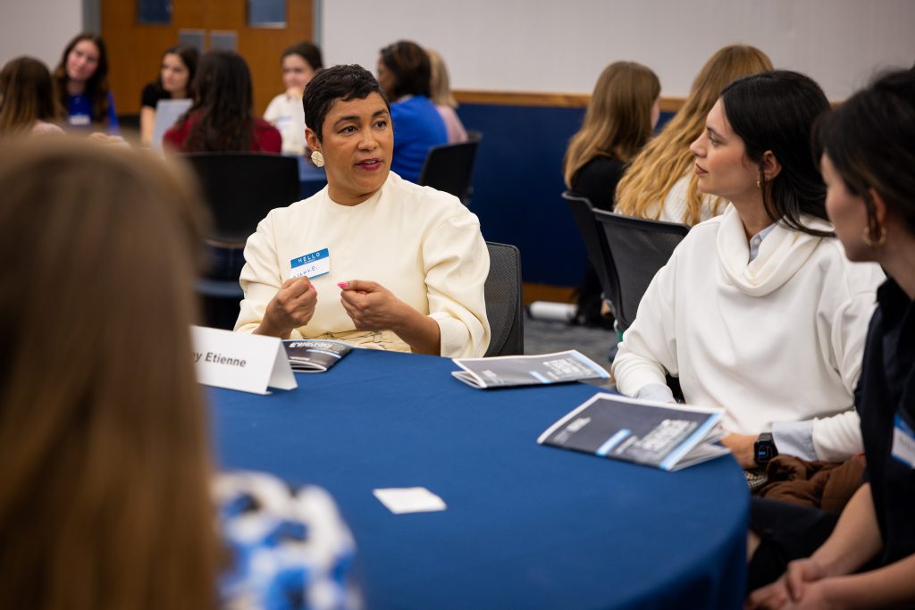 Ashley Etienne gestures and speaks to a student.
