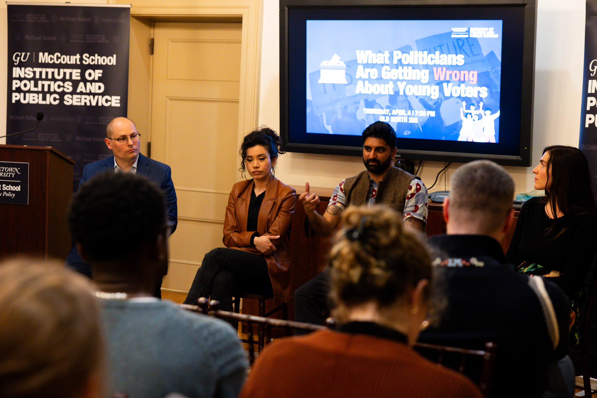 Waleed Shahid gestures and speaks while other panelists listen.