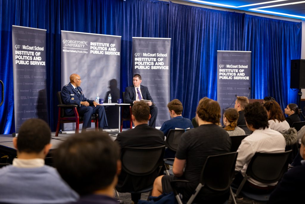 Lamothe and General Brown talk while audience members listen.