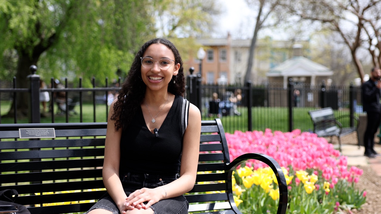 Christianna Doele sits on a bench near Copley Lawn smiling.