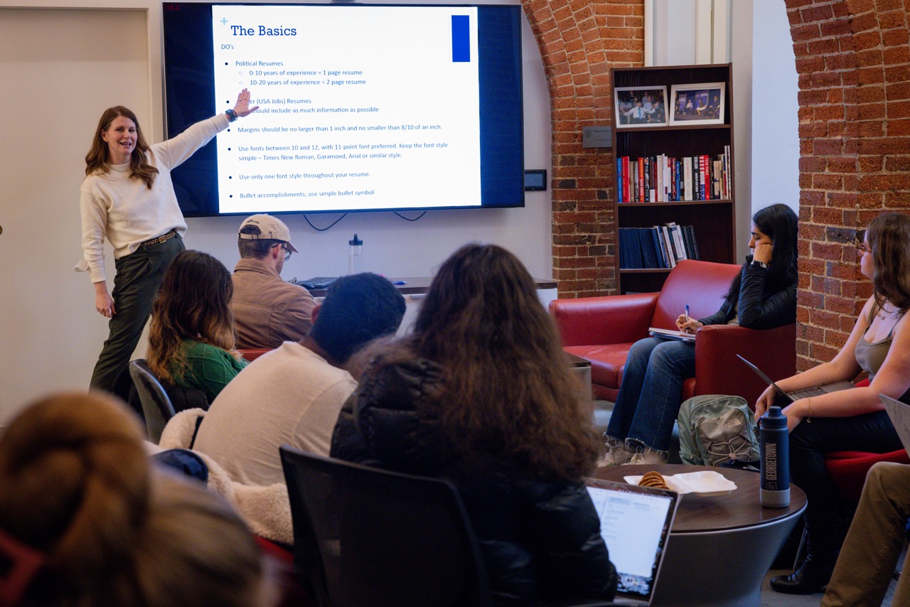 Jennie Fay points to her presentation on the screen as students in the Living Room listen.