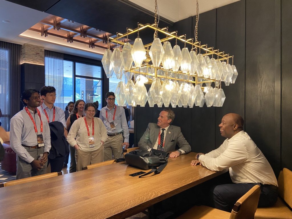 Students smiling and talking to Senator Tim Scott